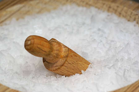 Close-up of coarse salt with wooden spoonの写真素材