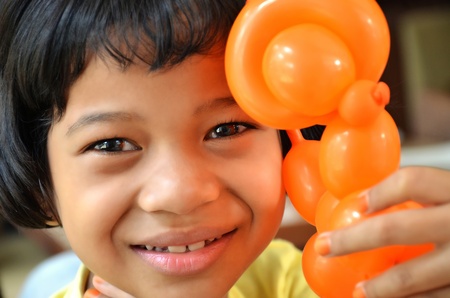 A happy asian girl posing with a baloonの写真素材