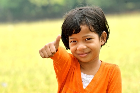 Young asian girl posing a thumbsの写真素材
