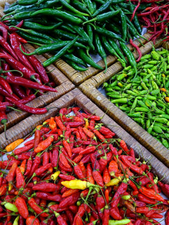 Four type of different chili on market stall displayの写真素材