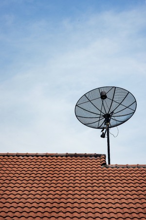 Satellite dish with sky on roofの写真素材