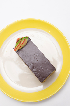 chocolate cake on white yellow edge plateの写真素材