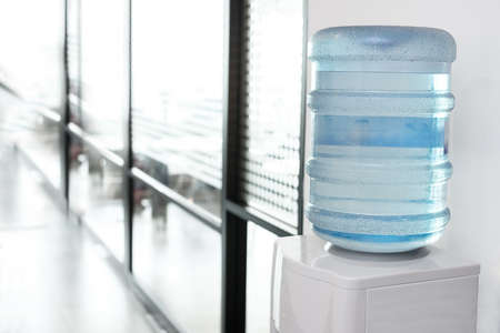 blue water gallon on electric water cooler in office areaの写真素材