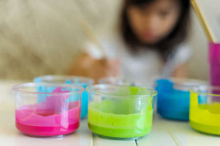 Out of focus shadow of little girl painting on the table in art subject  classroom at schoolの写真素材
