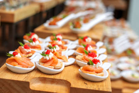 Cracker salmon caviar canape selection on wooden slate platter