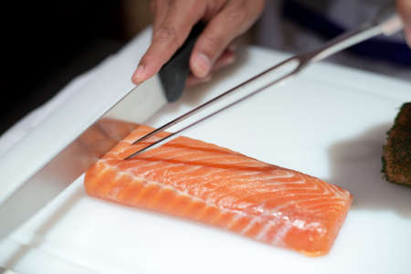 Professional chef cutting smoke salmon prepare for customer appetizerの写真素材