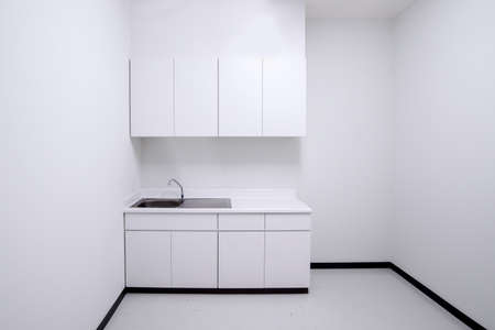 Clean empty white kitchen with sink and cabinetの写真素材