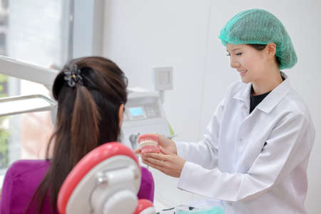 Smiling dentist talking with her patientの写真素材