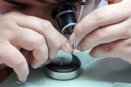 Watchmaker working on mechanical clockwork