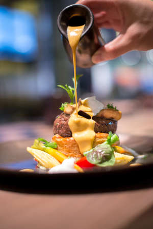 Waiter puring sauce on foie gras vealの写真素材