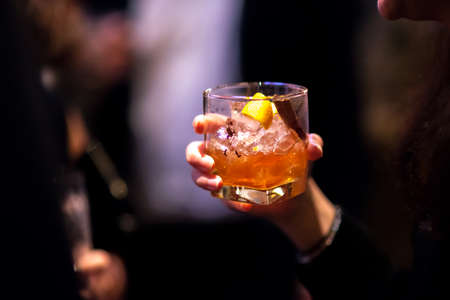 Girls hand on Glass of whisky cocktail