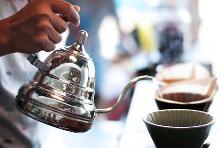 Hand drip coffee , Barista pouring water on coffee ground with filterの写真素材