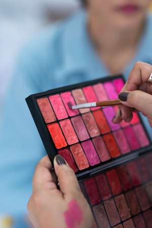 Make-up artist doing professional make up of young womanの写真素材