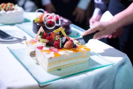 hand cutting colorful fruit cake in her birthdayの写真素材