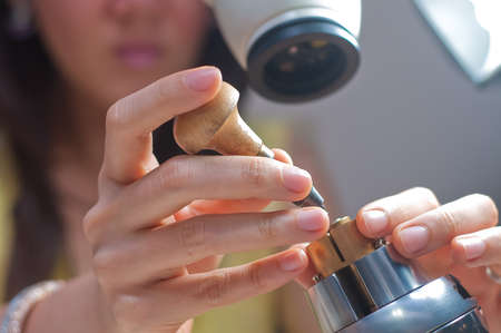 Lady delicately making  fine jewelry hand crafts on microscopeの写真素材