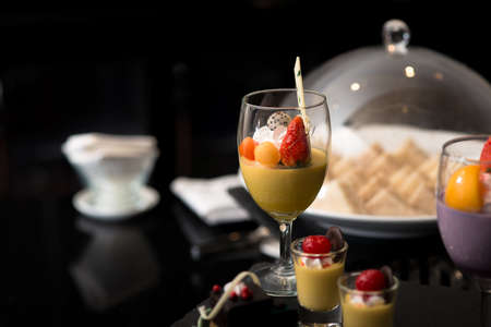 mango smoothie topped with several fruitの写真素材