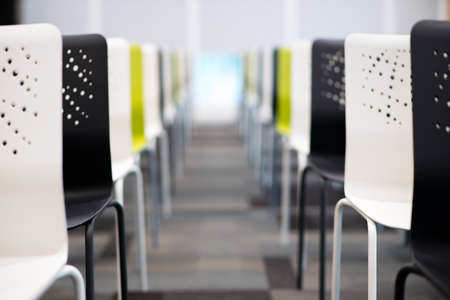 row of creative chairs in huge meeting roomの写真素材