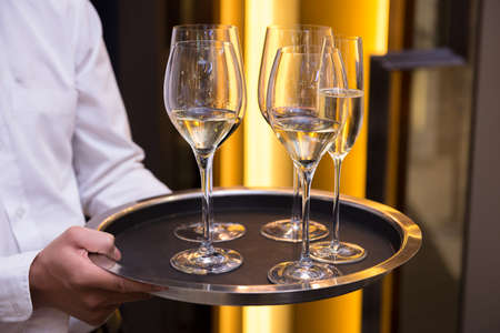 Waiter serving champagne and white wineの写真素材