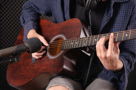 close up of man hand playing acustic guitar  in music studio record roomの写真素材