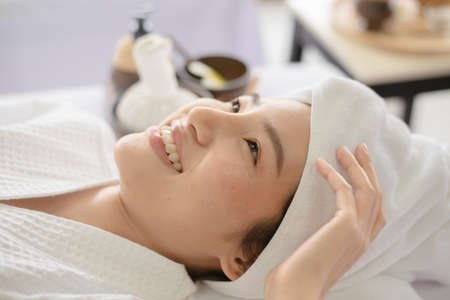 asian lady lying with smile in spa waiting for therapist do a threatment for her skinの写真素材