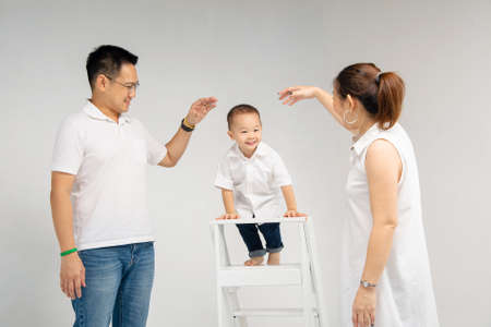 mon and dad unite take care of their son on stair in photography studioの写真素材