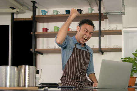 cafe owner raise his hand in the air celebrate gain sellの写真素材
