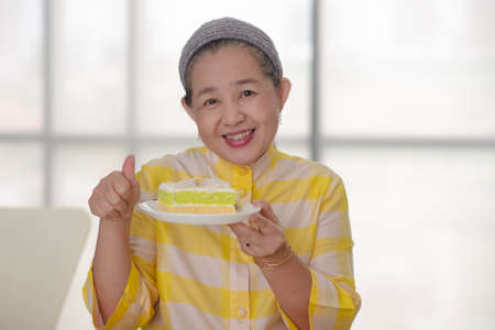 grandma with dessert on her handの写真素材
