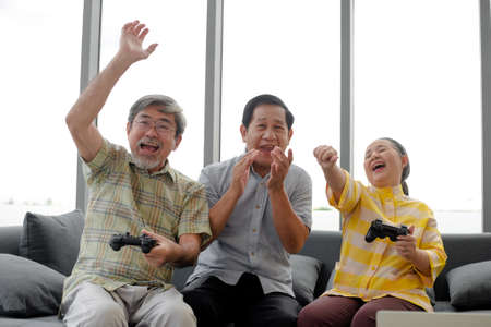 group of retired friends happy on game consoleの写真素材