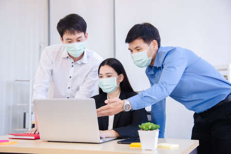 people talking with surgical mask for virus protection in workplaceの写真素材