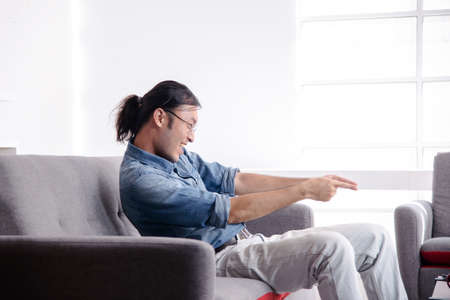 asian guy point his fingers to the right side of picture with massive happinessの写真素材