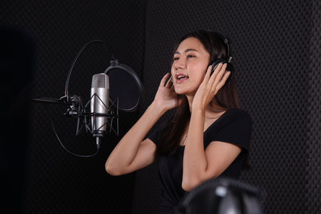 Young lady sing a song in music studio roomの写真素材