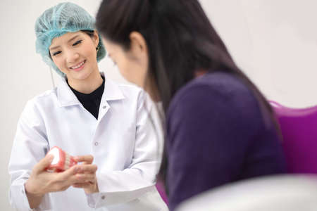 dentist talking with her client in dental clinicの写真素材