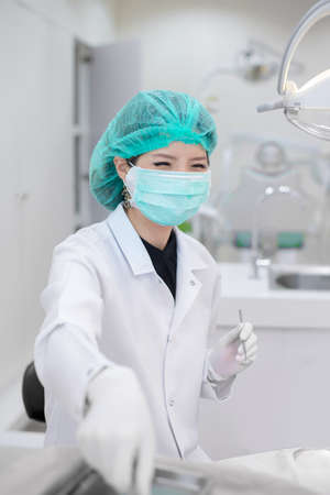 female dentist wear surgecal mask on duty in dental clinic