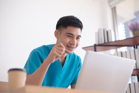 Braces Dentist smiling with floss in hand on his deskの写真素材