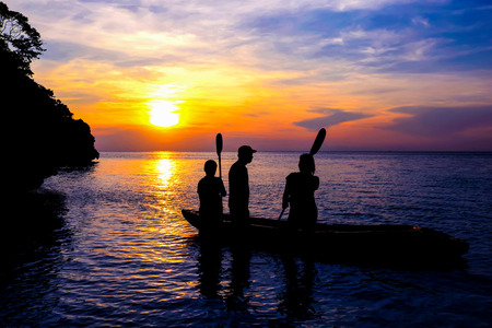 The family with kayaking on the beach at sunset.の写真素材