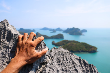 Hands climbing the rock at the viewpoint Angthong island.の写真素材