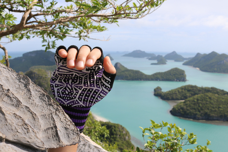 Rock Climbing,Hands with gloves on the mountain at the viewpoint Angthong island.の写真素材