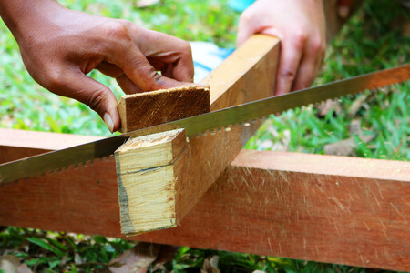 The hand is sawing wood