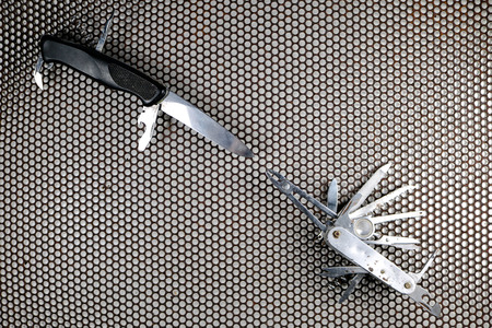 The Multifunction knife with steel mesh background.の写真素材
