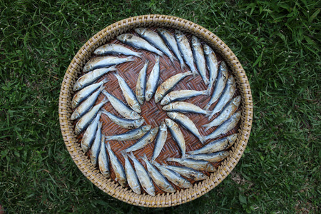 Dried salted fish on the wicker baskets.