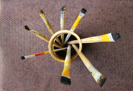 Paintbrush in bamboo vase with steel mesh background.の写真素材