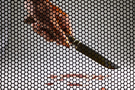 Knife and a bloody hand.concept, shooting through the steel mesh to see the shape of the image.