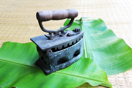 The old iron on banana leaf.の写真素材