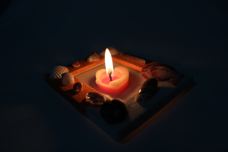 Heart-shaped candle in the shell frame.の写真素材