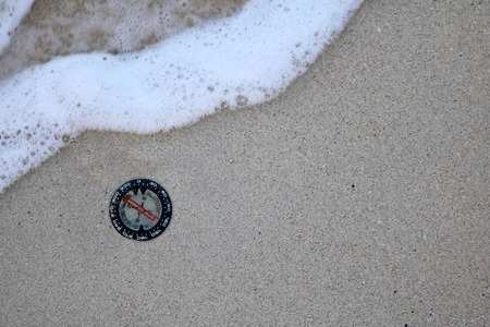 Compass in the sand on the beach.の写真素材