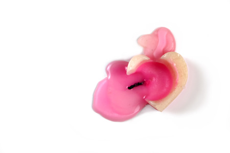 Heart-shaped candlelight almost extinguished with white background.の写真素材