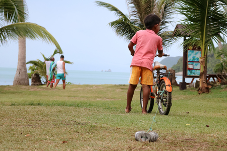 The boy with the bike on the coconut beach.の写真素材