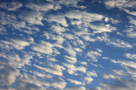 Pattern of white clouds streaming by wind with blue sky background.