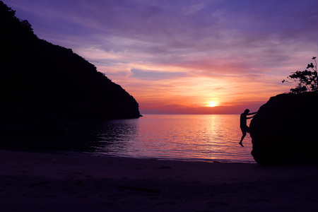 Rock climbing with sunset on the beach.