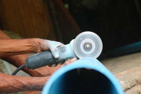 Asian workers use electric circular saw cutting the PVC pipeの写真素材